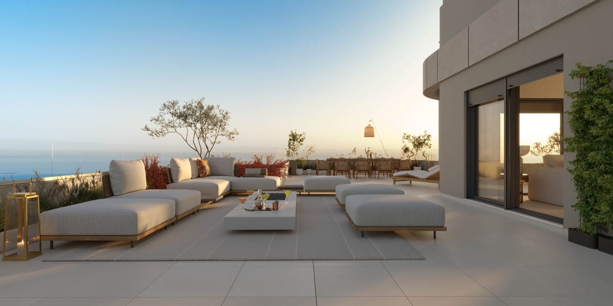 Project visualisation of the ONE OAK terrace at sunset with modular sofas, a coffee table, a dining table in the background and the sea on the horizon.