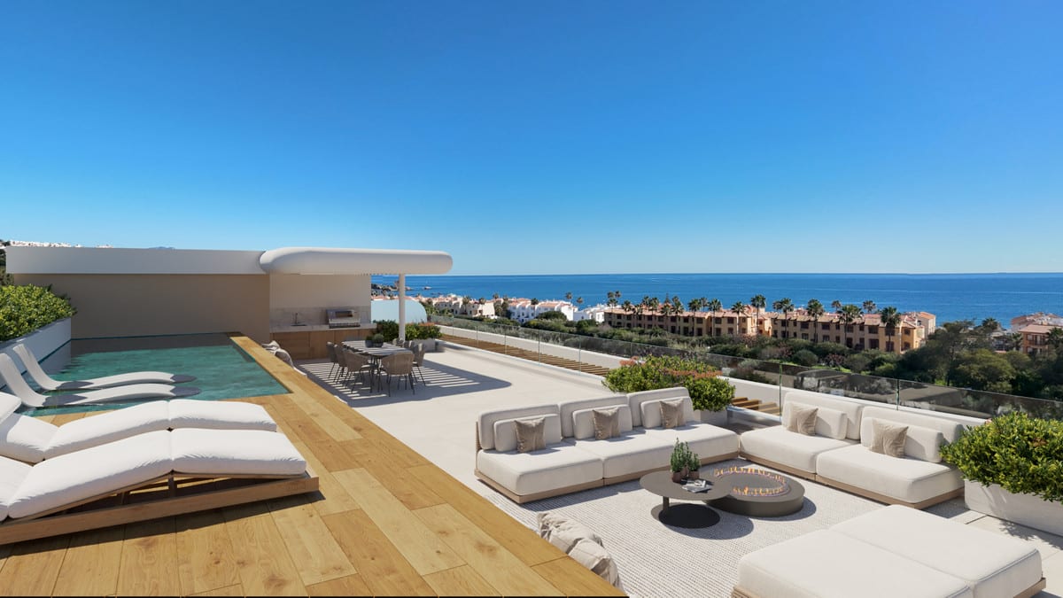Project visualisation of PRIVILEGE SUITES with a roof terrace, narrow swimming pool, white sun loungers on a wooden deck, outdoor kitchen, dining table, lounge sofas with a round fire table and sea views in the background.