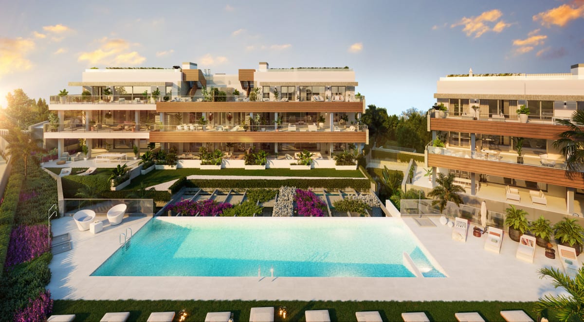 Project visualisation of QUINTESSENCE at sunset, with a rectangular swimming pool, sun loungers, planted terraces and white buildings with timber cladding.