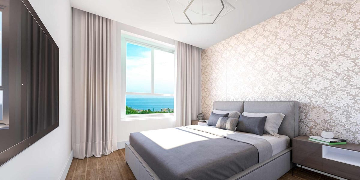Project visualisation of RESIDENCIAL PACARAIMA - ADOSADO with a bedroom, grey upholstered double bed, damask-patterned wallpaper and a window with sea views.