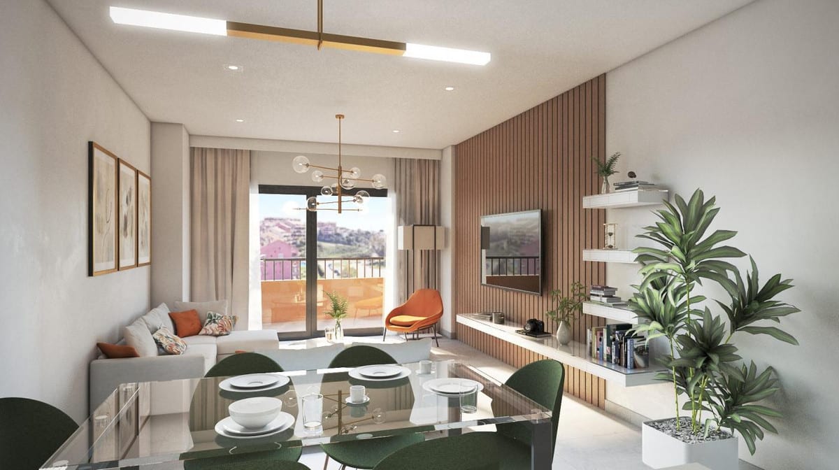 Development visualisation of RESIDENCIAL SUNHILL featuring a living and dining area: a glass dining table with green chairs, grey sofa with orange cushions, orange armchair, television on a wooden slatted wall, gold pendant light and a large glass door to a balcony.