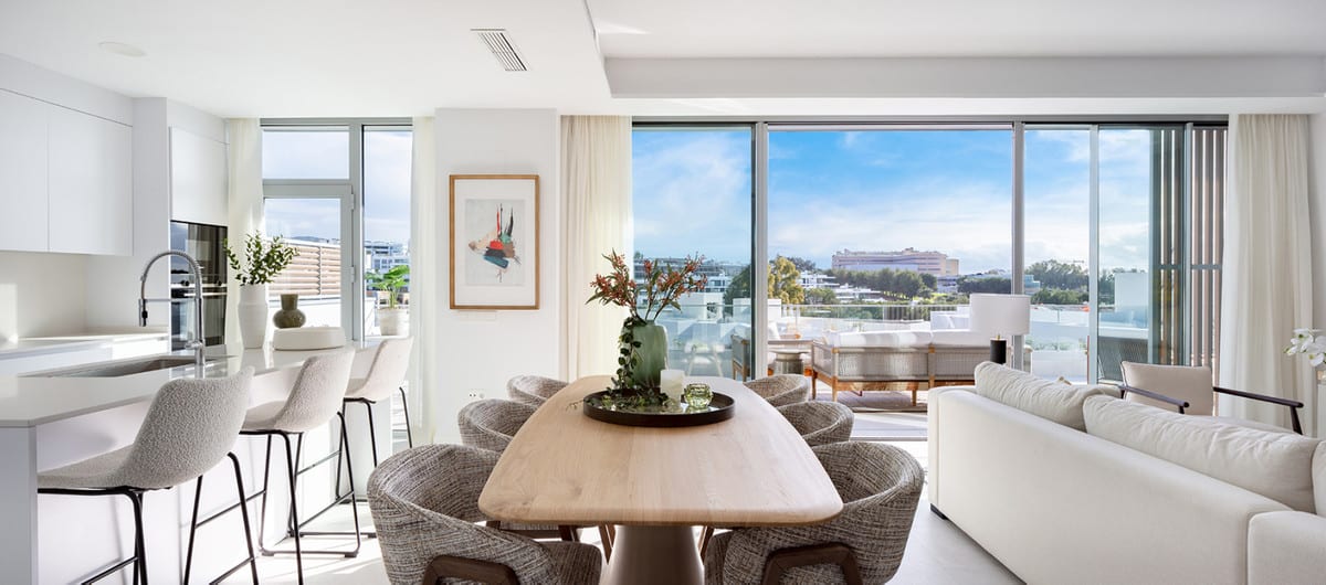 Project visualisation: open kitchen, dining and seating areas beside large glass doors to the terrace.