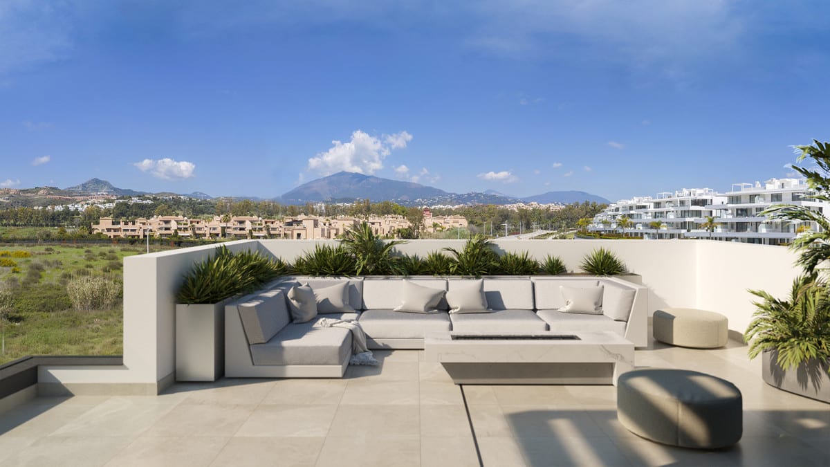 Project visualisation of SERENE ATALAYA II / III featuring a roof terrace, corner sofa, low table, planters and views of the mountains and surrounding buildings.