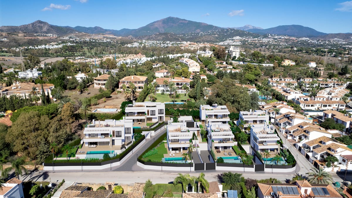 This aerial photograph shows the layout of SEVEN DIAMONDS with clean white volumes, terraces, pools and planting, with mountains in the background.
