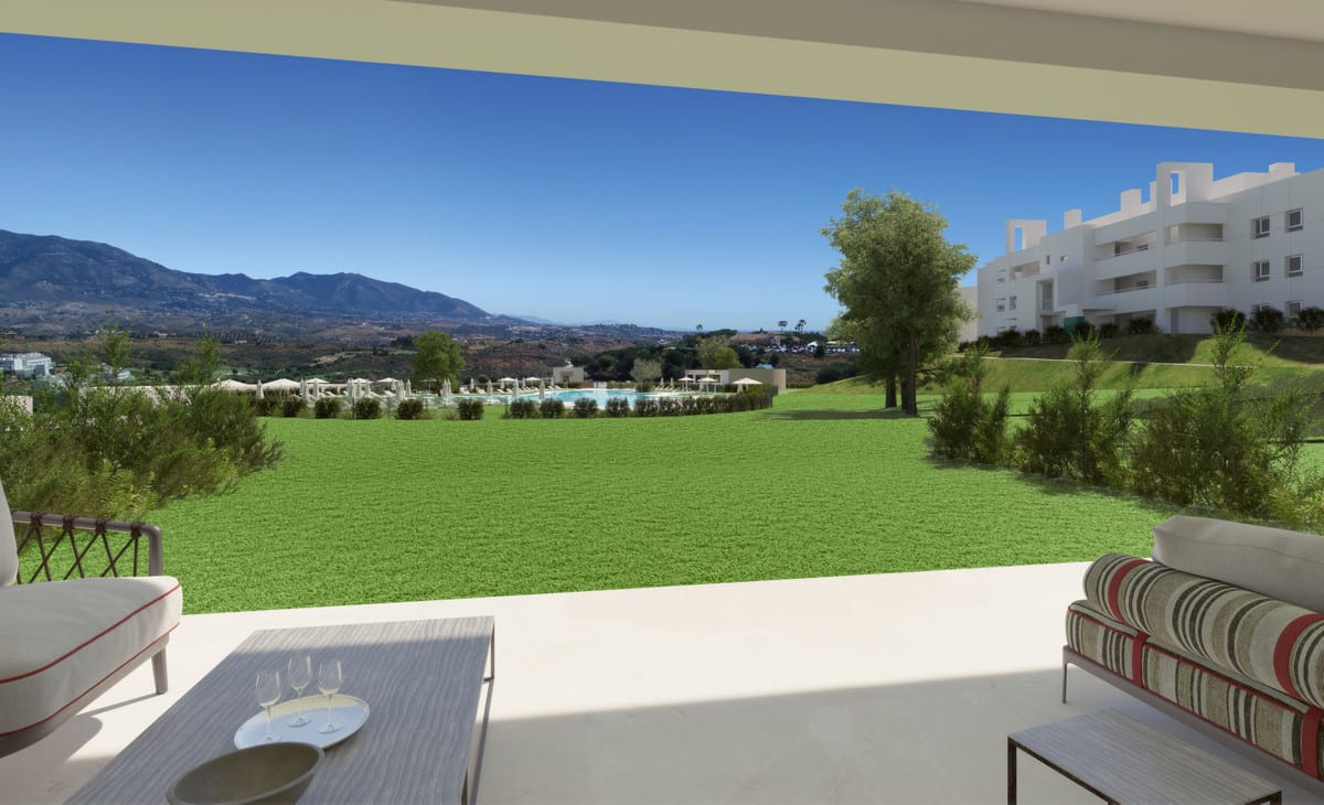 Project visualisation of SOLANA VILLAGE featuring a terrace with lounge seating, a low table with wine glasses, green lawn, the pool area in the background, and a mountain and valley panorama.