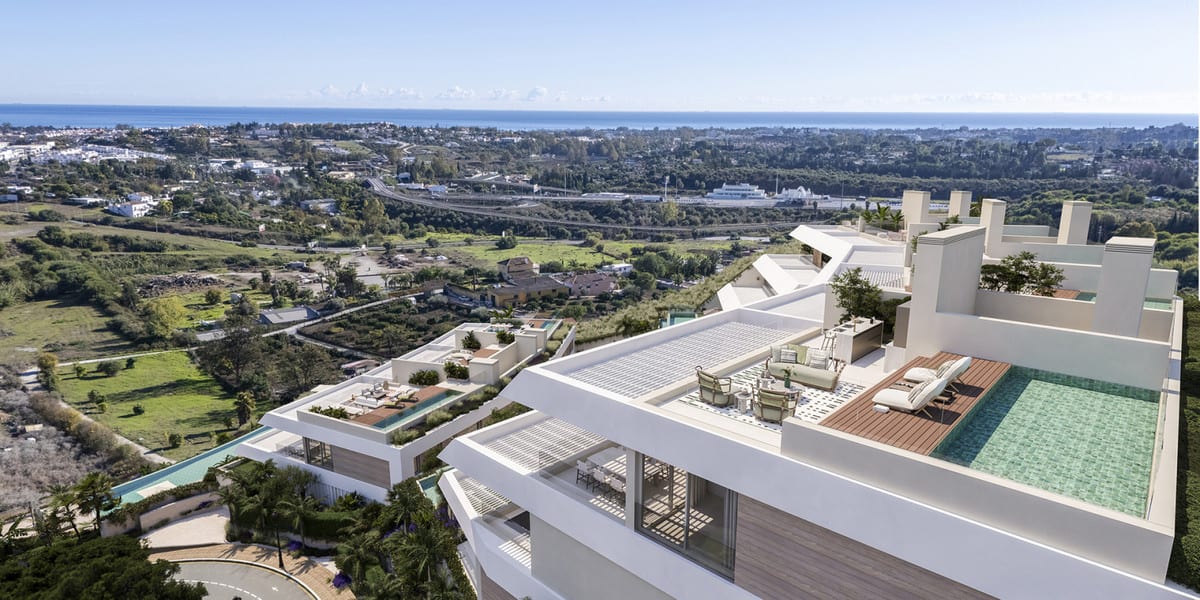 Aerial visualisation of SOLENNE with white roof terraces, a louvred pergola, seating, wooden decking and a rectangular swimming pool with an expansive landscape in the background.