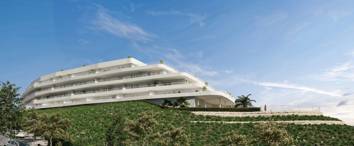 Development visualisation of SUNSET VIEWS featuring a long white building with several continuous balconies above a planted slope.