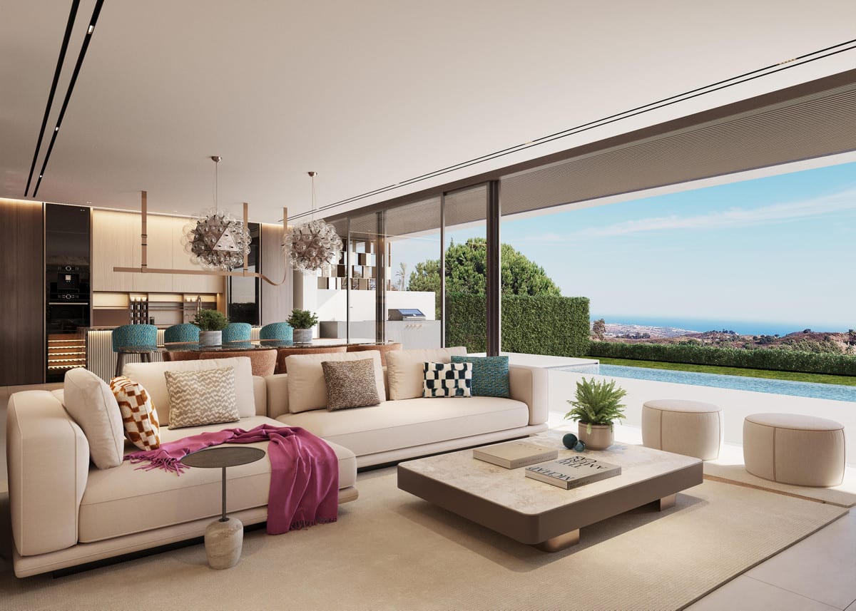 Project visualisation of TERRA NOVA HILLS featuring a bright living area, cream sofa, stone coffee table, clustered glass pendant lights, an open-plan kitchen in the background and large glazed façades overlooking a swimming pool, landscaped garden and coastline.