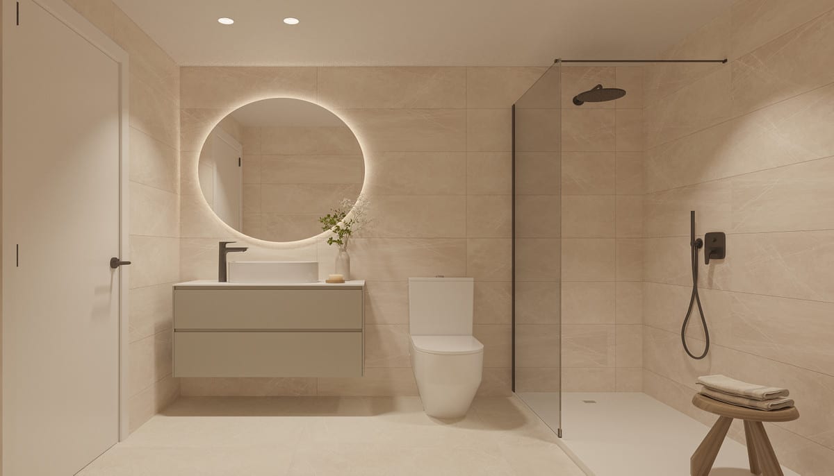 Rendered bathroom at THE KOVE with large beige wall tiles, a floating vanity unit with a countertop basin, toilet, glass shower screen with rainfall shower and a round illuminated mirror.