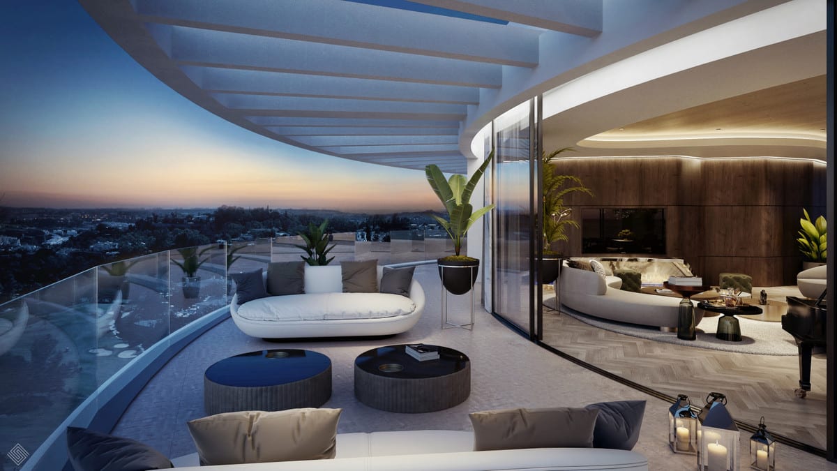Evening visualisation of a curved terrace with lounge seating and an adjoining illuminated living room.