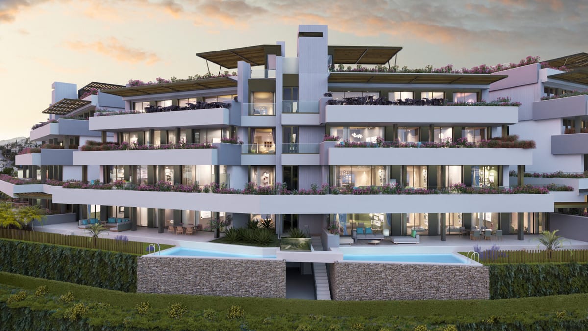 Project visualisation of TIARA with a multi-storey white façade, balconies with flowering planters, large glazed frontages with illuminated interiors, wooden pergola elements on the roof and one elongated swimming pool in the foreground.