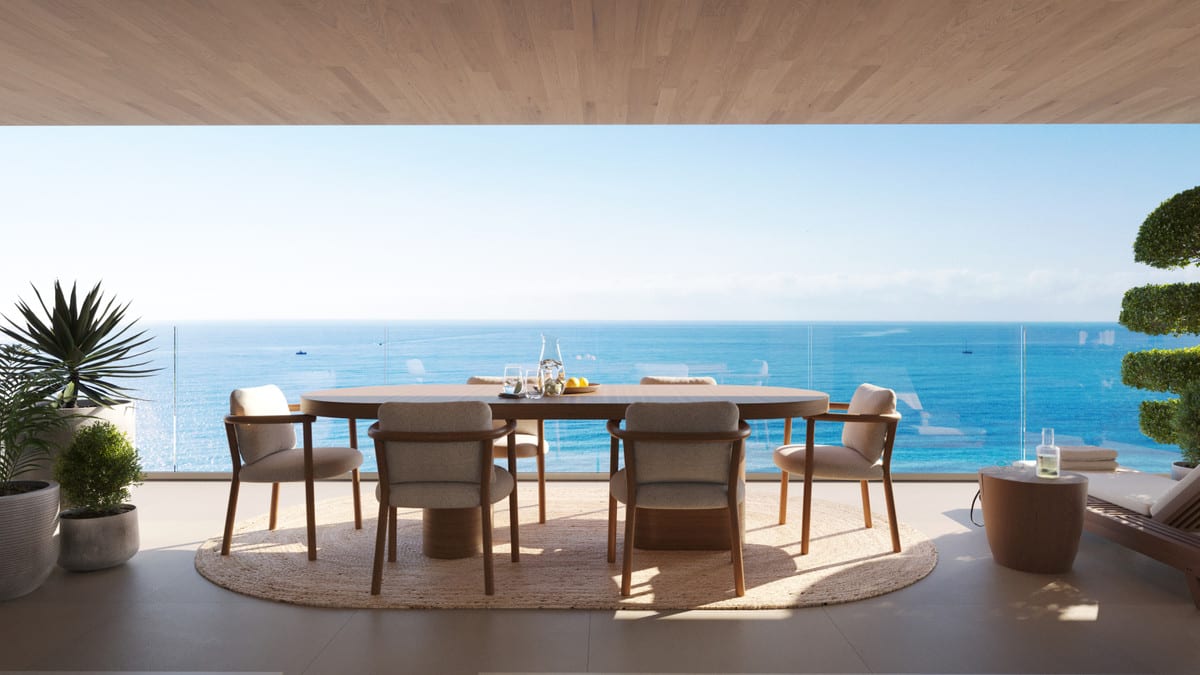 Rendered terrace view of TORRE BIZNAGA with an oval wooden dining table, six upholstered chairs on a round jute rug, glass balustrade and sea in the background.