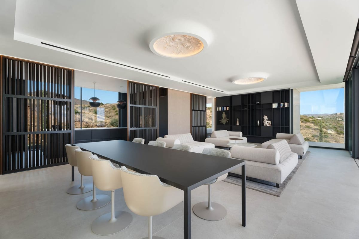 Visualisation of a dining and living area with a dark table, pale sofas and slatted partitions.