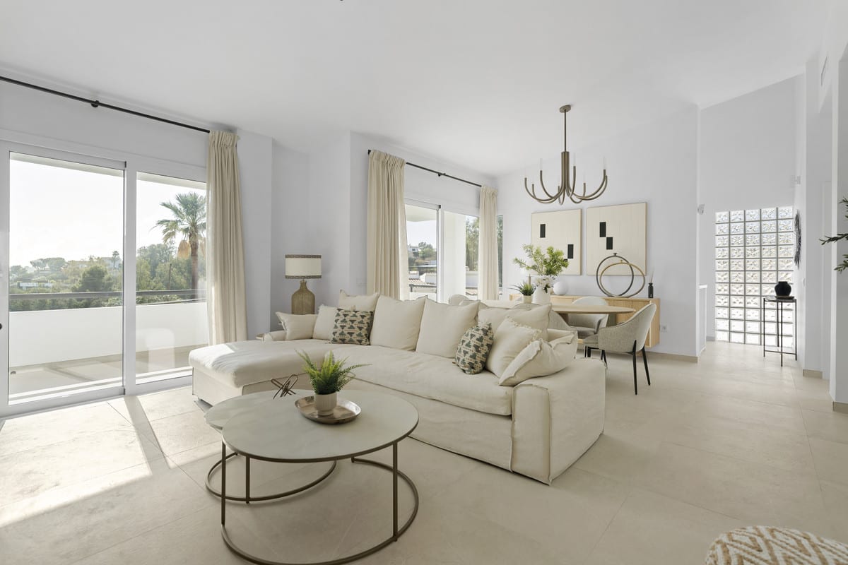 URBANIZACIÓN OLIMPO living room with a cream corner sofa, sliding glass doors with cream curtains and a view through to an adjoining room.