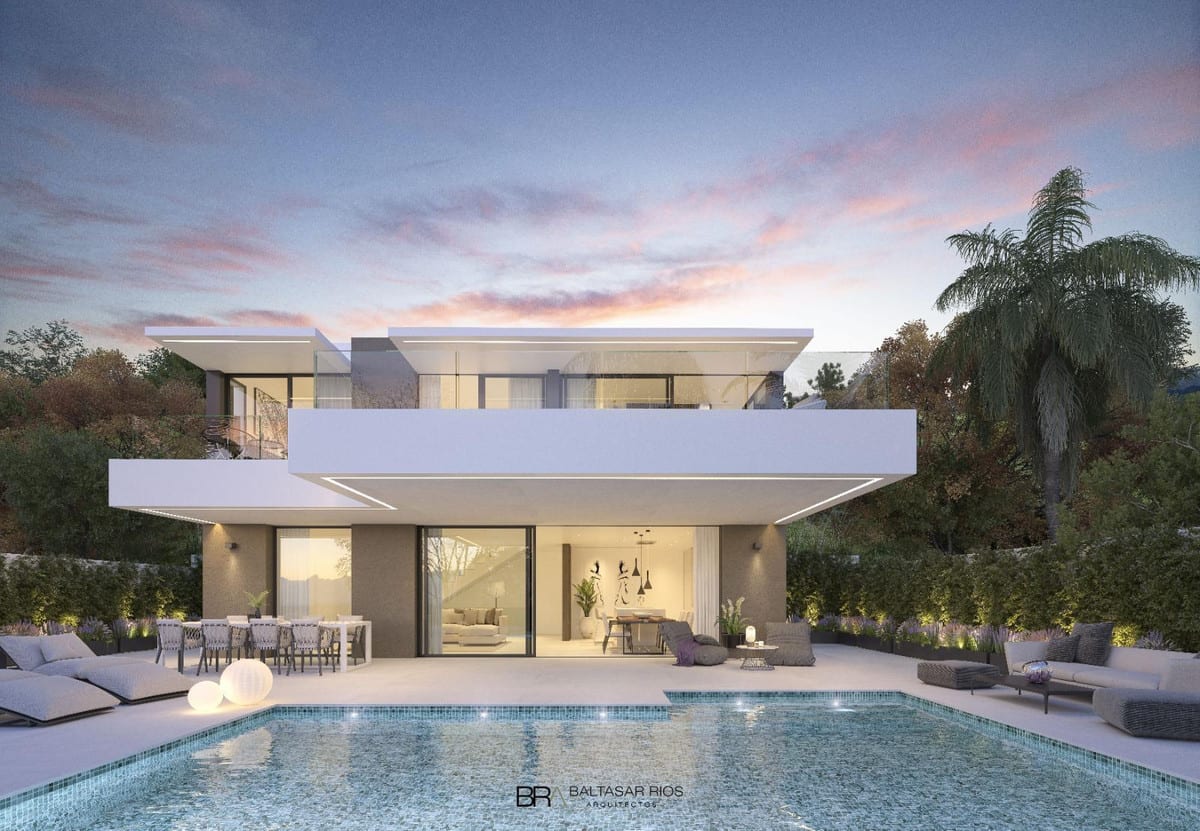 Rendered project visualisation of VILLA ALCALÁ DEL VALLE at dusk: a white two-storey building with large glazed façades, illuminated interiors, a covered terrace with dining and seating areas, and a rectangular swimming pool in the foreground.