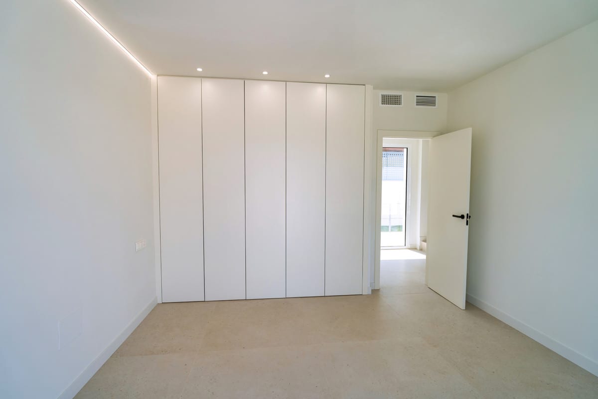 VILLA SANTHAI 3 Y 9 room with a wide white five-door fitted wardrobe, beige tiled flooring, ceiling spotlights and indirect LED lighting
