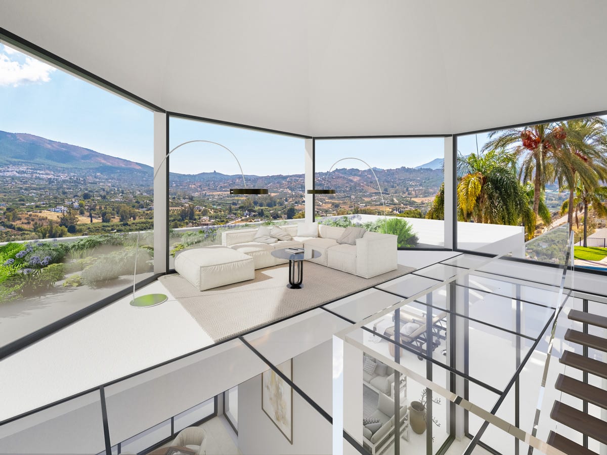 Image of VISTA DEL REY MIA&AIM with a white corner sofa on a glass floor, panoramic curved windows all around, a glass balustrade and a dark staircase on the right-hand side.