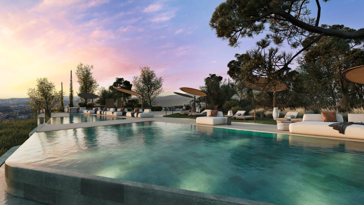 Project visualisation of WATERFALL RESIDENCES with a large swimming pool, white sun loungers, parasols with taupe canopies and mature trees in the evening light.