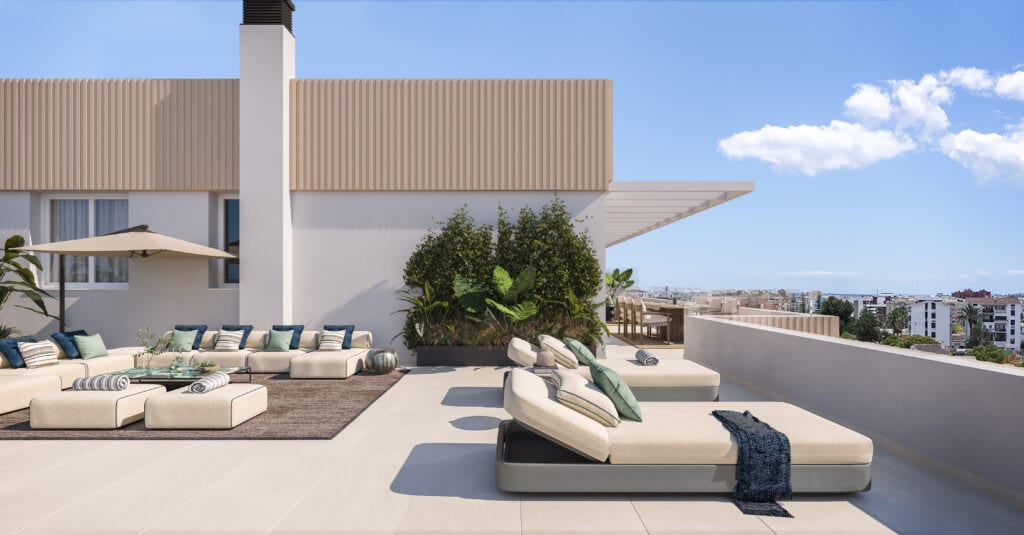 Development visualisation of ZENITH ESTEPONA featuring a spacious rooftop terrace, two sun loungers in the foreground, a lounge set with cushions, planted containers, a white roof overhang and an urban panorama in the background.