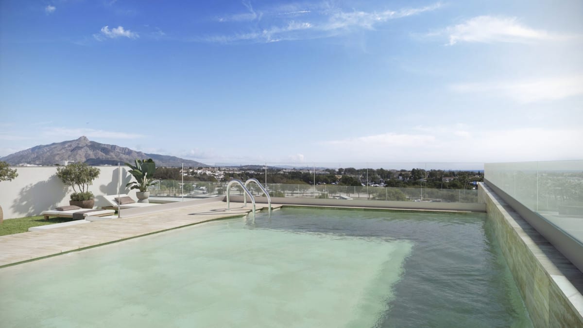 Project visualisation of ZINNIA featuring a swimming pool on a terrace, glass balustrades, a sun lounger and mountains in the distance.