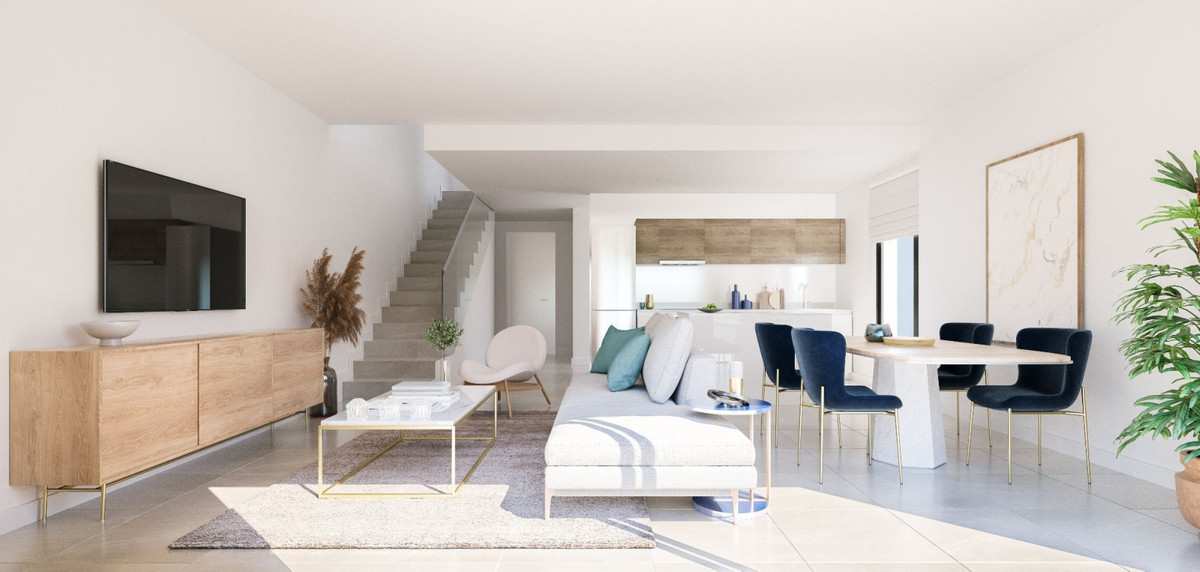 Eksempelinteriør med lys sofa, lavt sofabord, spisebord, åbent køkken bagest og synlig trappe; billedet bekræfter ikke indretningen af en bestemt ledig bolig.