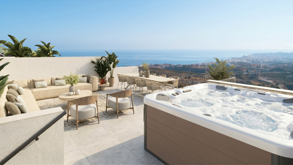 Visualisering af en tagterrasse med stor jacuzzi til højre, lys hjørnesofa, lave borde og potteplanter til venstre; bebyggelse, kyst og hav ses bag glasgelænderet.