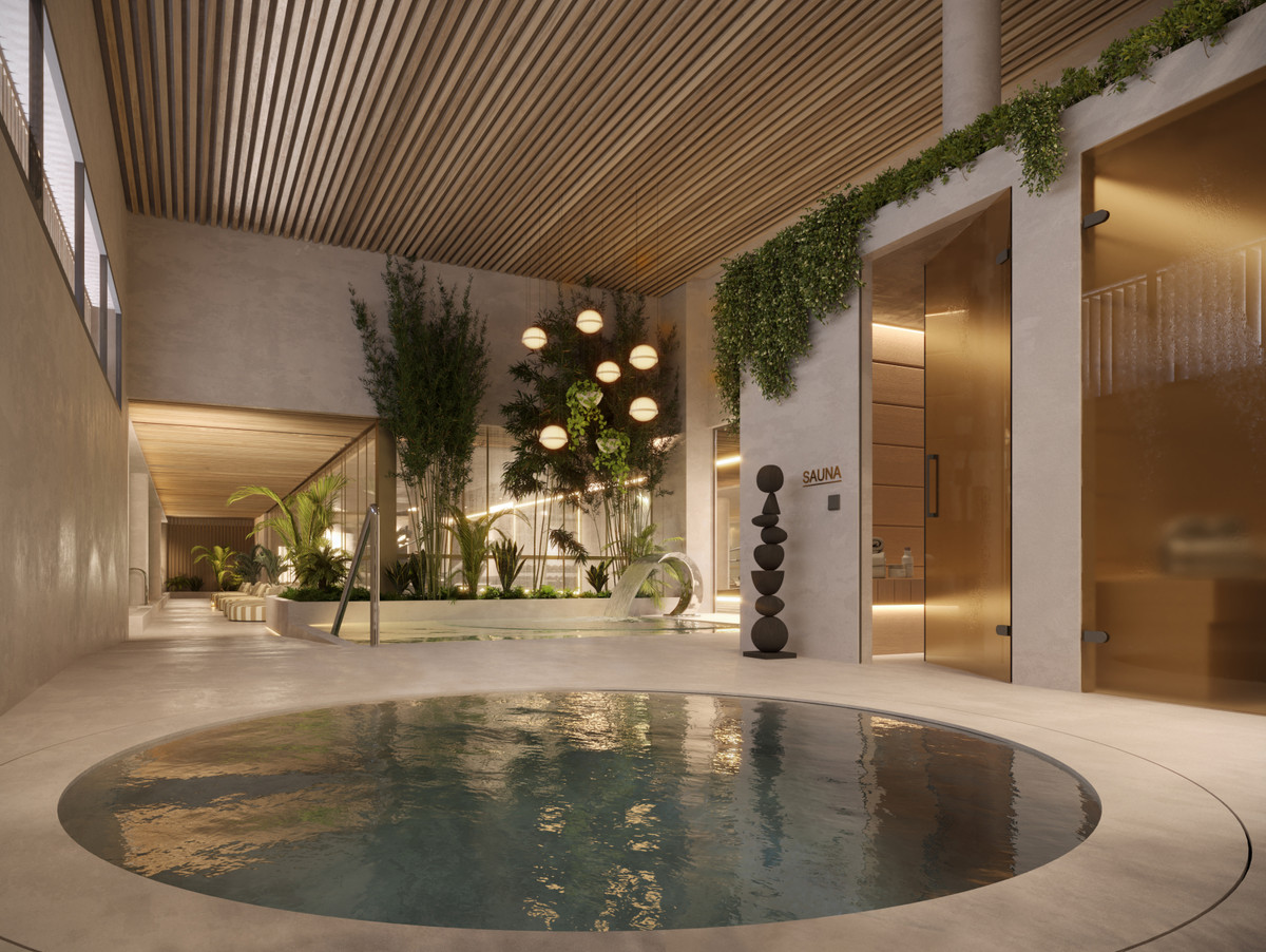 Visualisering af et indendørsrum med rundt bassin, trælameller i loftet og grøn væg; billedet illustrerer den planlagte wellnessindretning i THE GROVE.