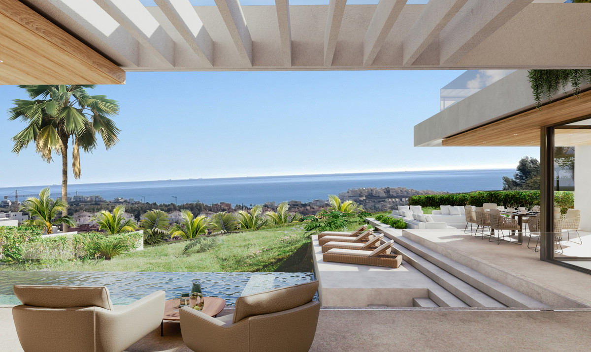 To lænestole står under en åben hvid pergola; bag dem ligger en lavere pool, en hævet siddeplads, palmer og havet ved horisonten.