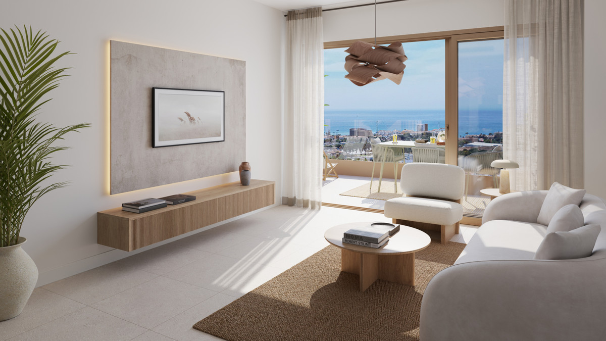 Visualisering af en lys stue med sofa, lave borde og brede glasdøre til terrassen, med kysten synlig uden for den foreslåede indretning.